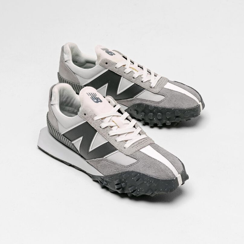 Pair of grey XC-72 sneakers sitting in a grey studio backdrop.