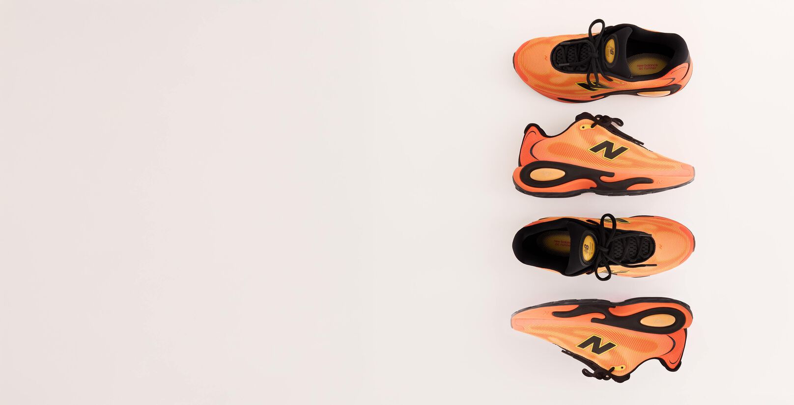 Two pairs of orange AC Runner shoes on a grey background.