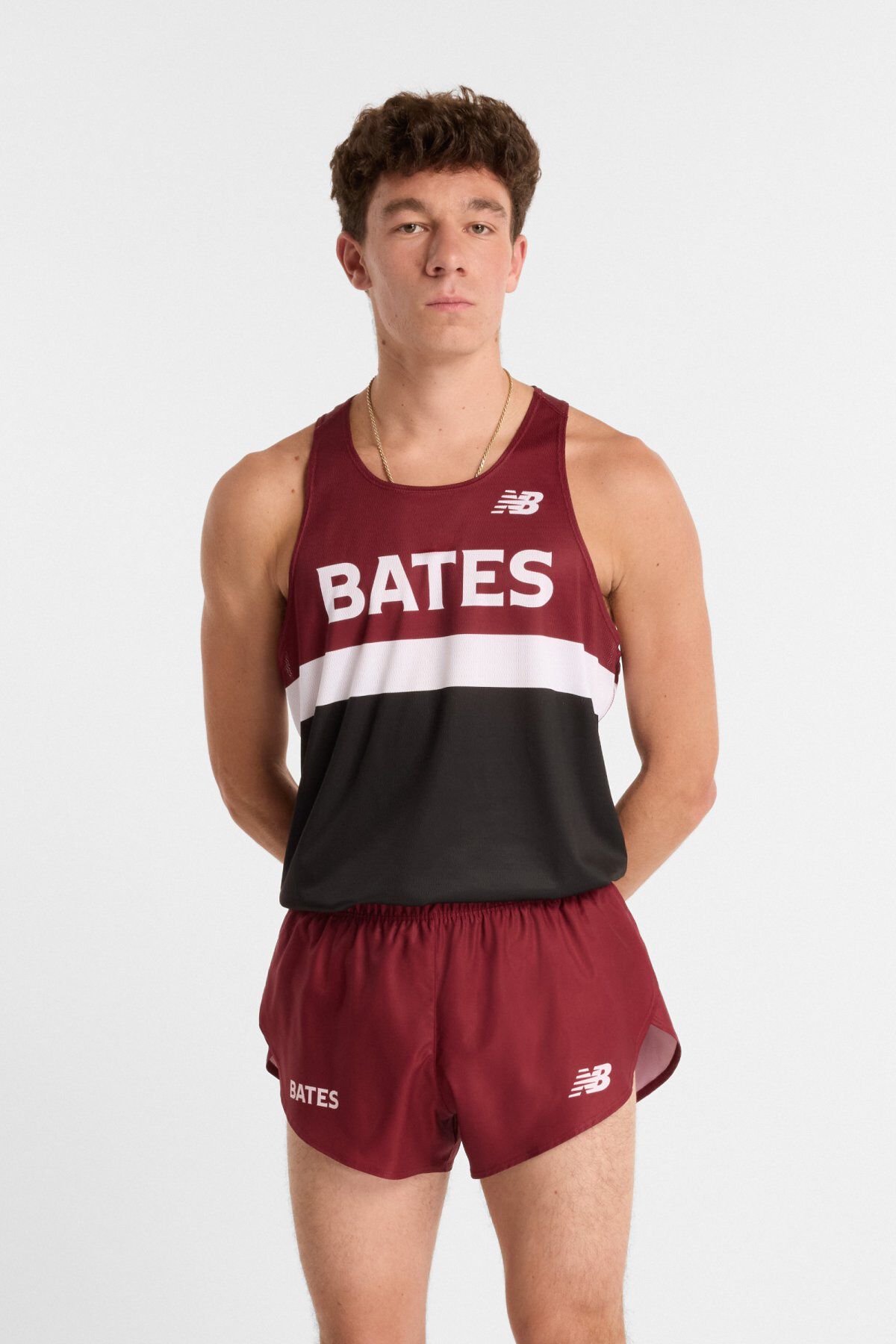 Male runner wearing a maroon and black Bates track uniform with matching shorts, standing against a light background.
