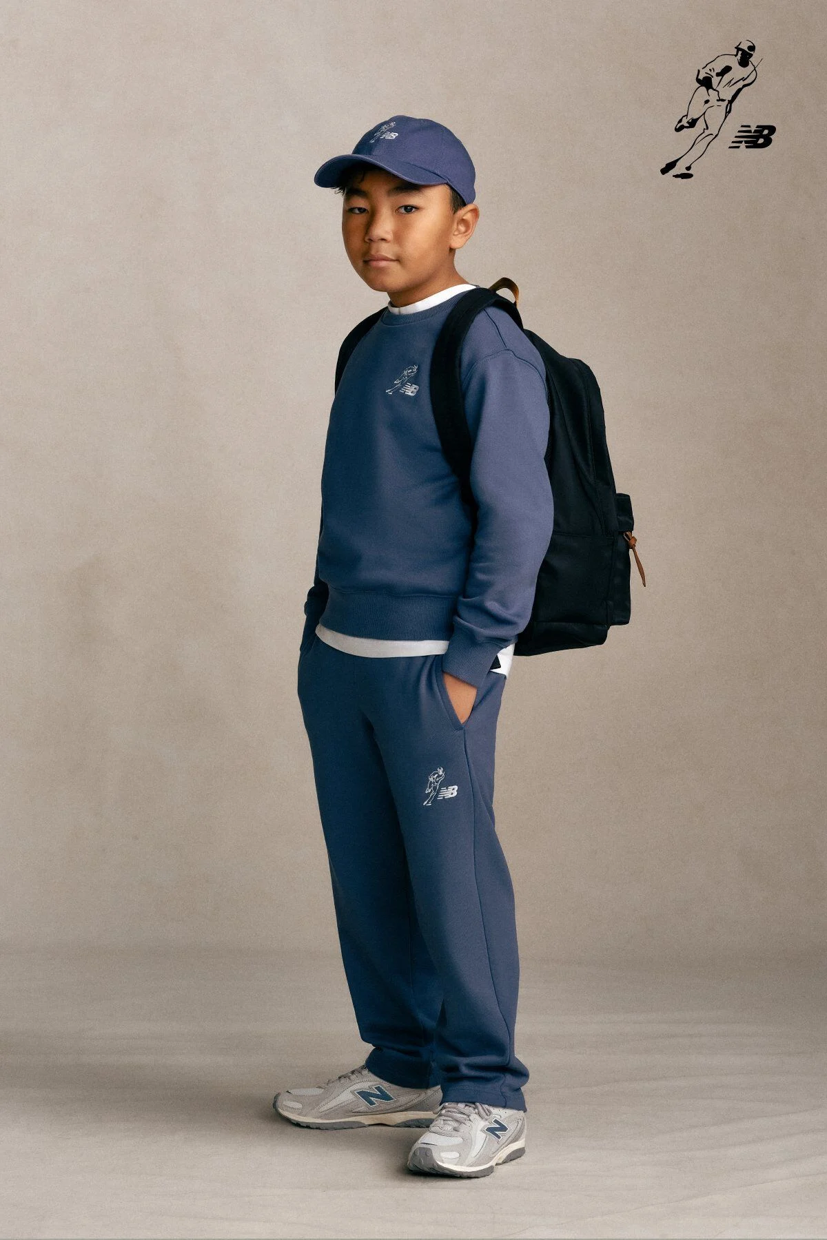 Kid standing against a grey studio background.