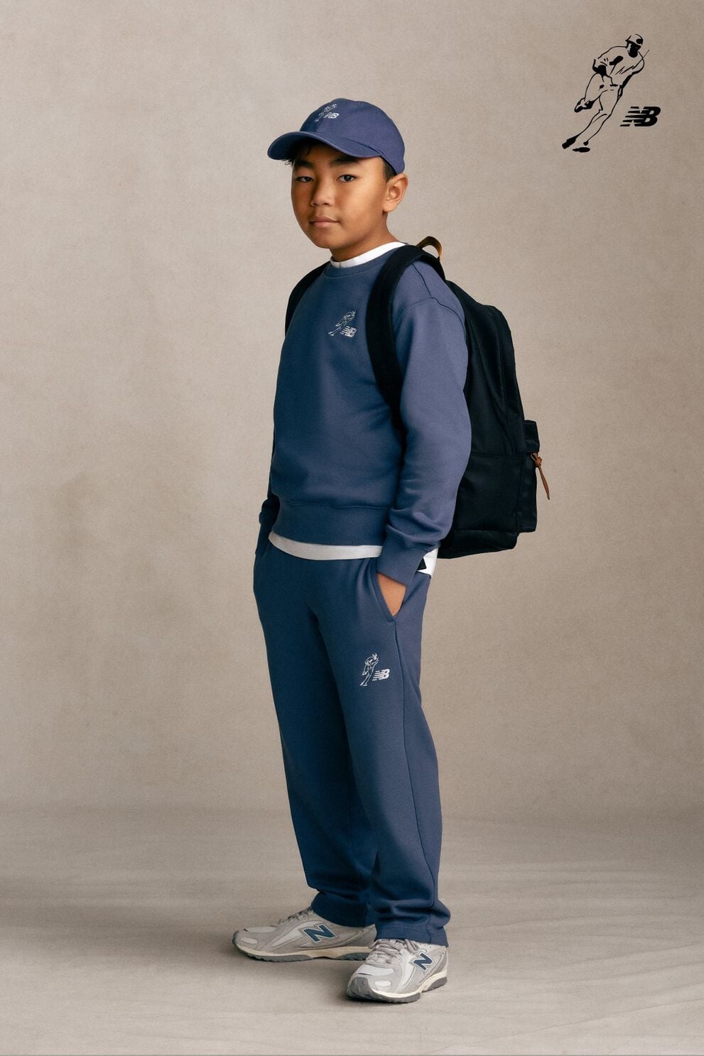 Kid standing against a grey studio background.