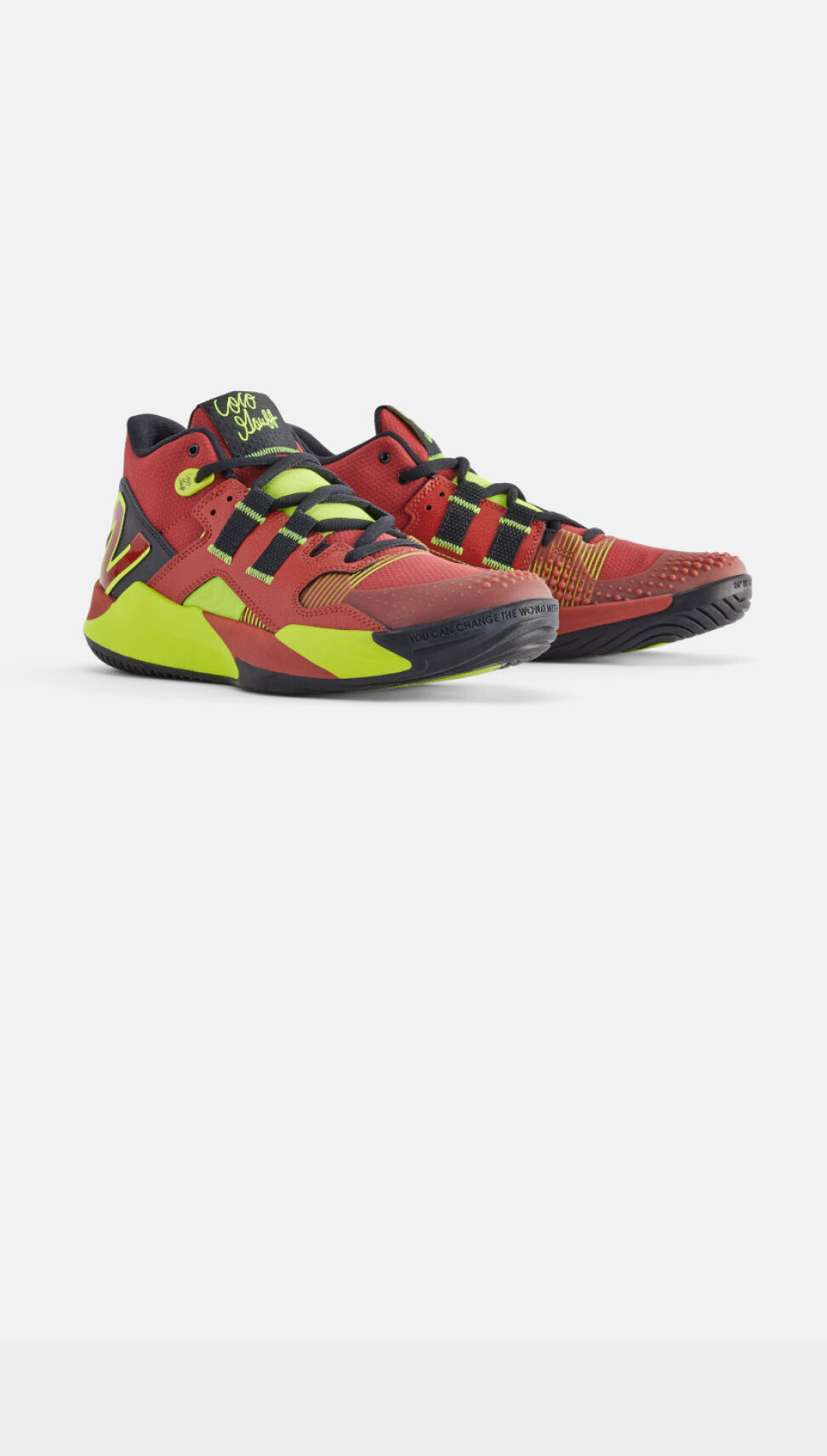 Pair of red and neon green shoes sitting on a grey background. 