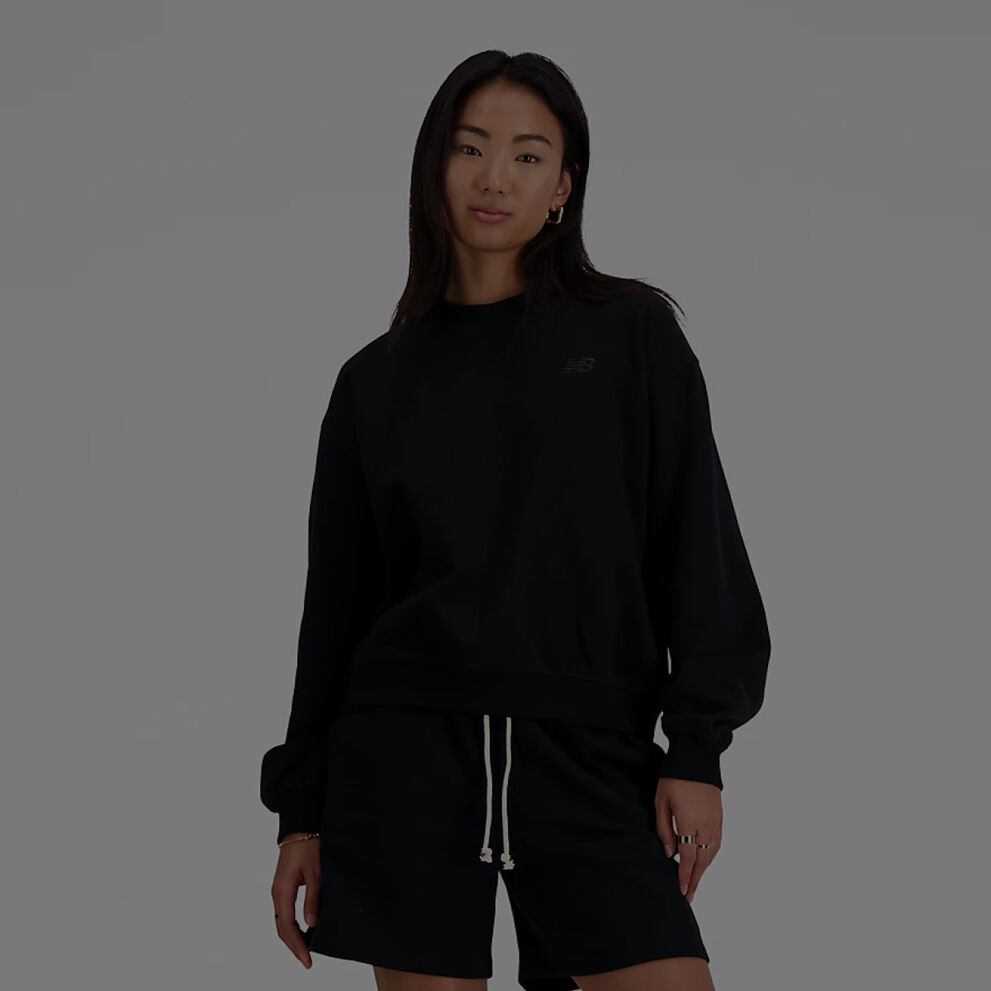 Woman in long sleeve black New Balance shirt and matching black shorts. 