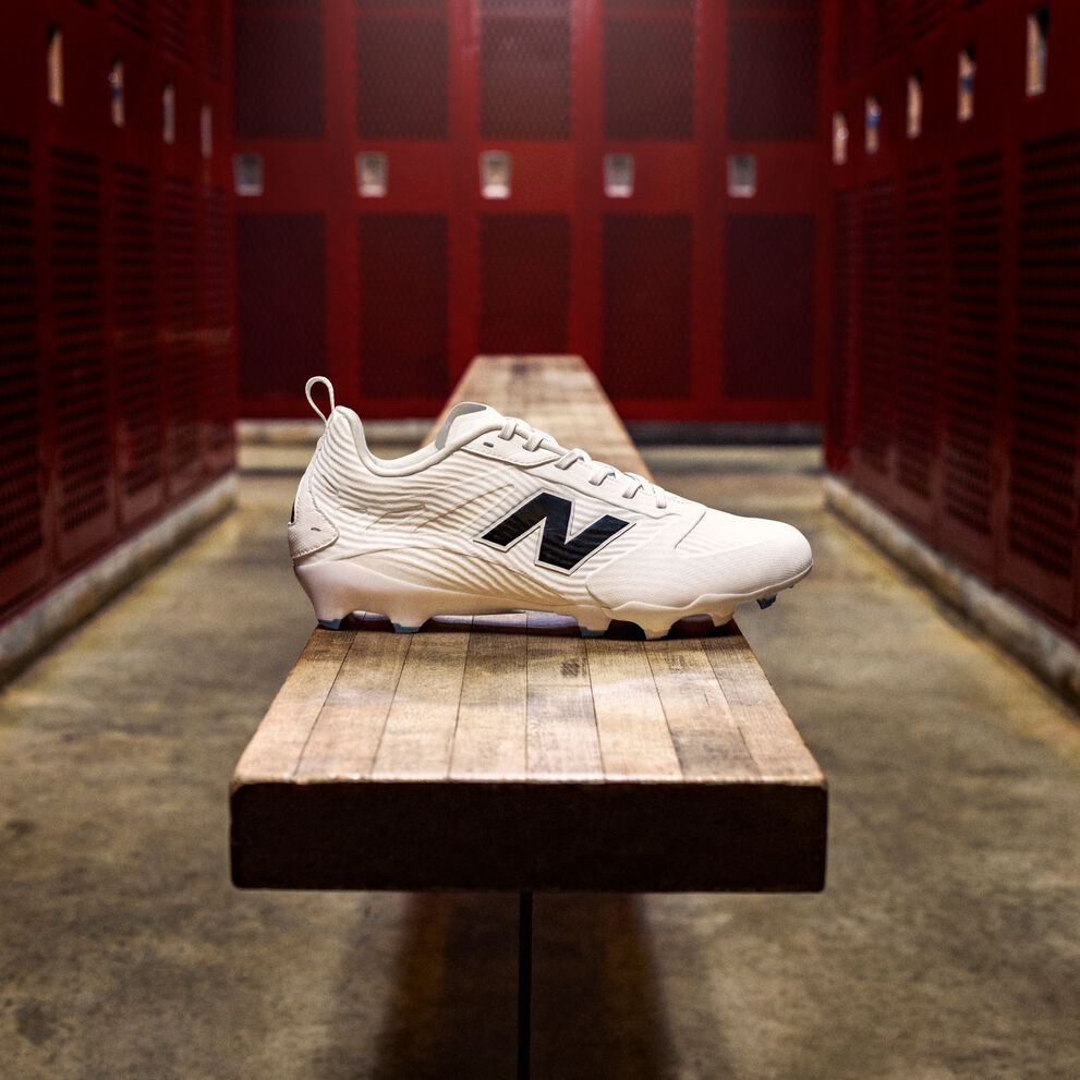 A white Rev iQ football cleat on a bench in a locker room.