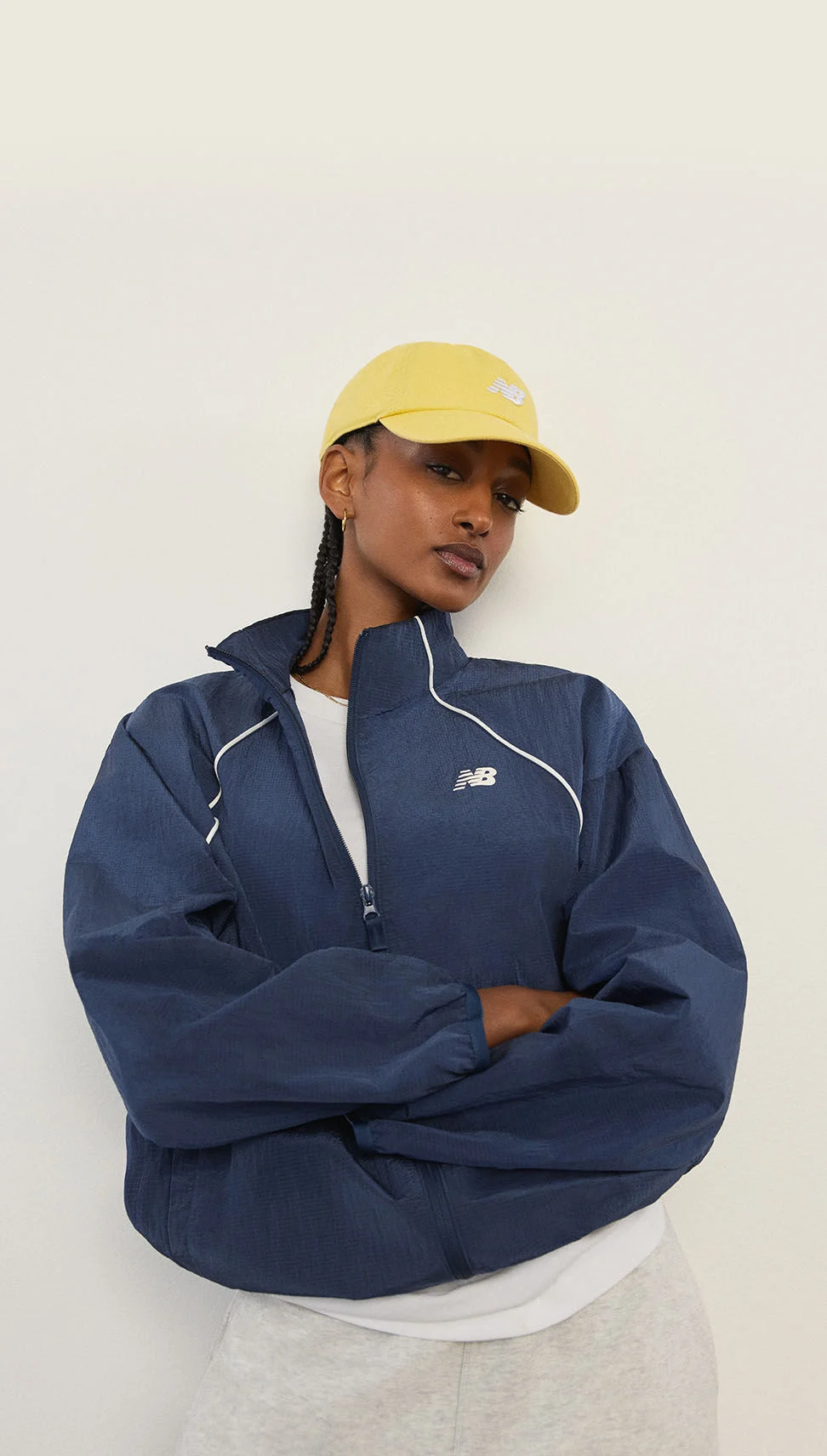 A woman standing in front of a white wall.