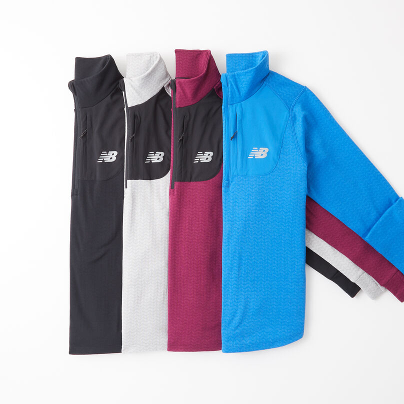 Four men’s long sleeve jackets laying on top of each other on a grey background.
