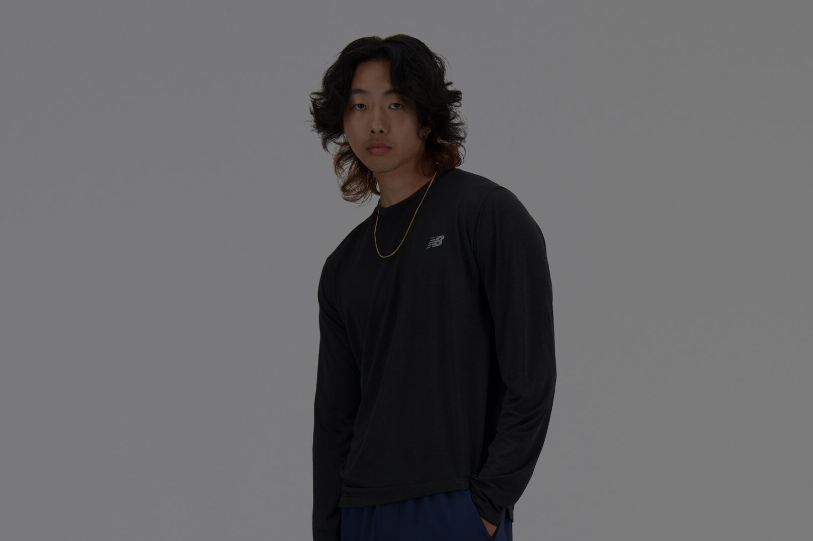 Man in long sleeve black New Balance shirt. 