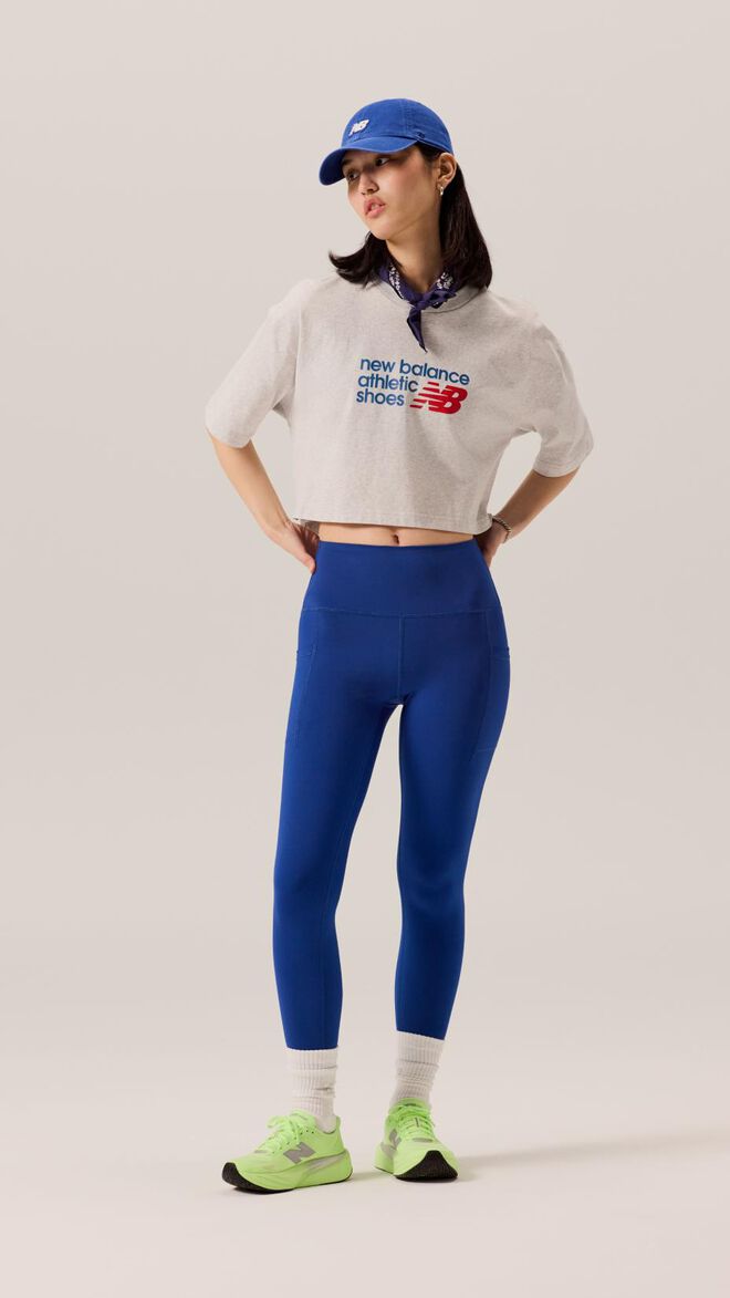 Chica joven vestida con medias azules y camisa blanca con un sombrero azul. 