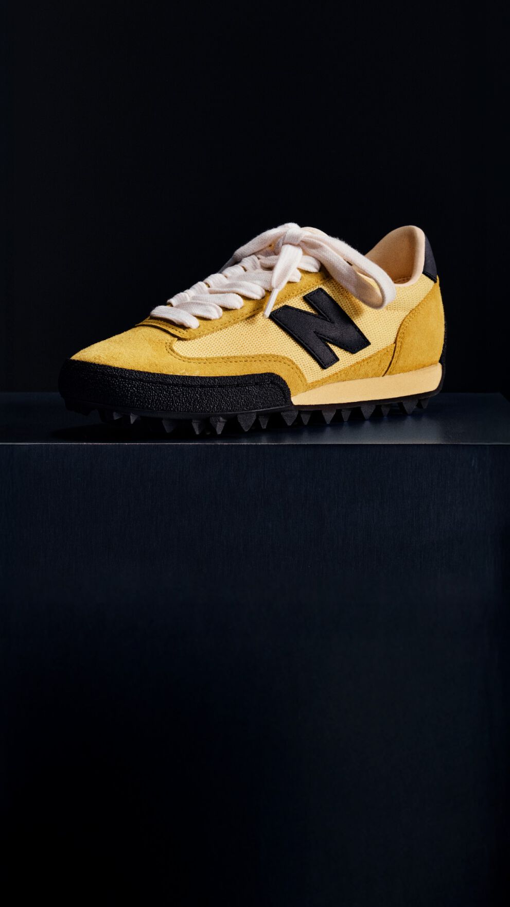  Single yellow sneaker on a black background 