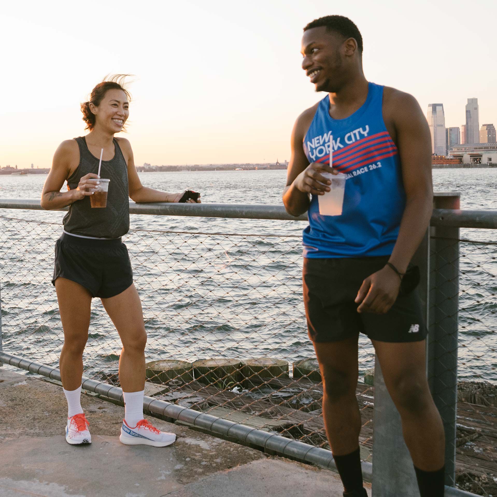 Man and woman in singlets standing along the river