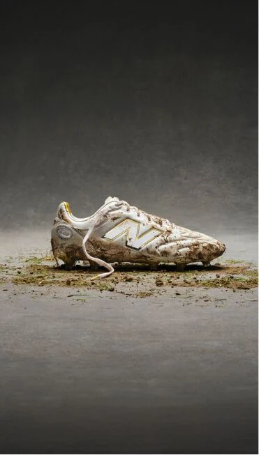 White and gold cleats covered in dirt and grass