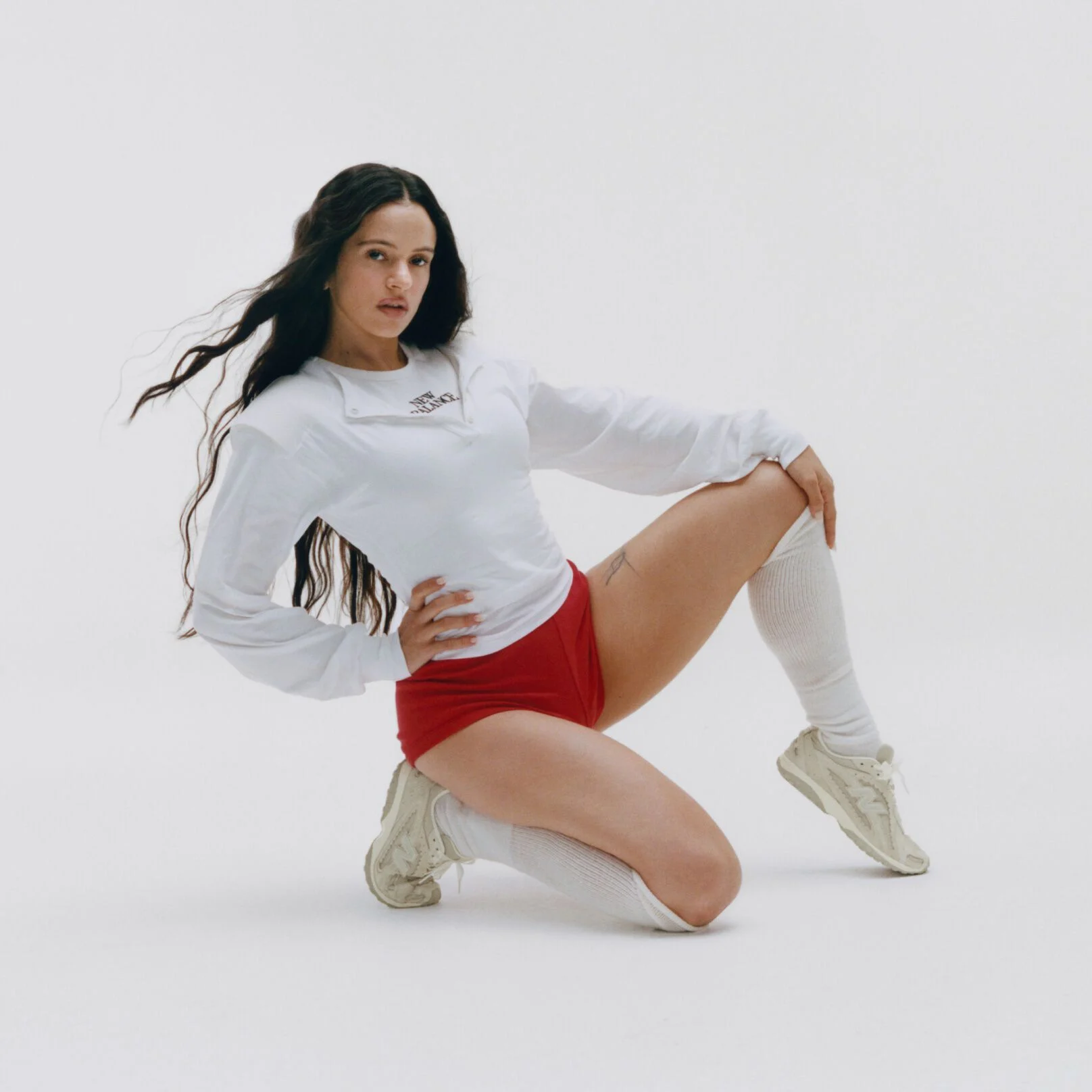 Rosal&iacute;a kneeling on a white studio backdrop.