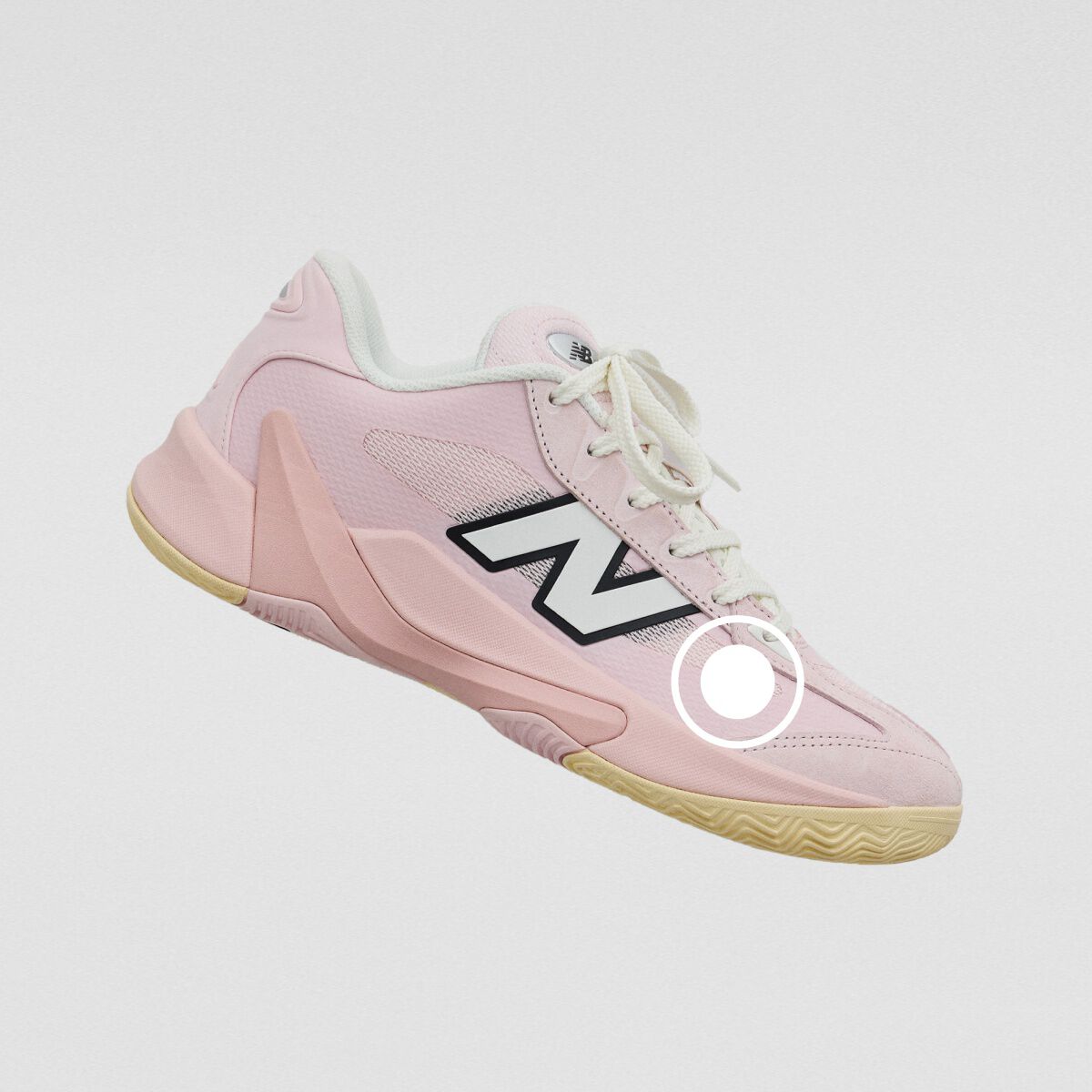 Light pink New Balance athletic sneaker with a mesh upper, oversized side logo, and gum rubber outsole.