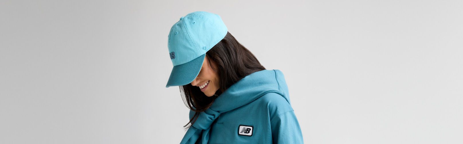 A close-up shot of a female looking to the side while wearing a &lsquo;47 hat. 