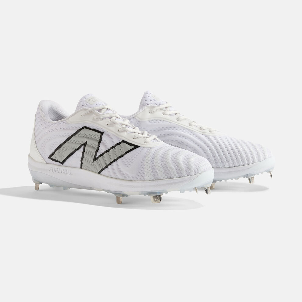 Pair of white baseball cleats sitting on a grey background. 
