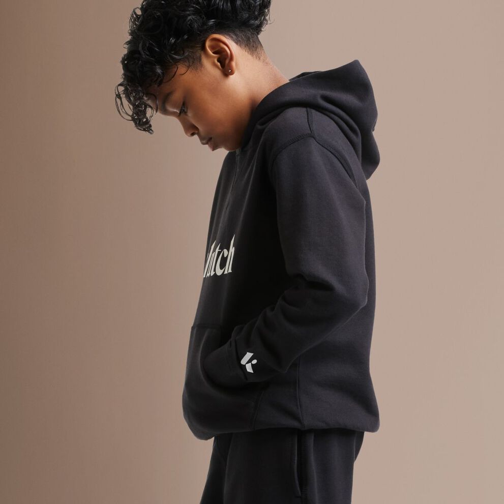 Kid in a black hoodie looking at the ground.