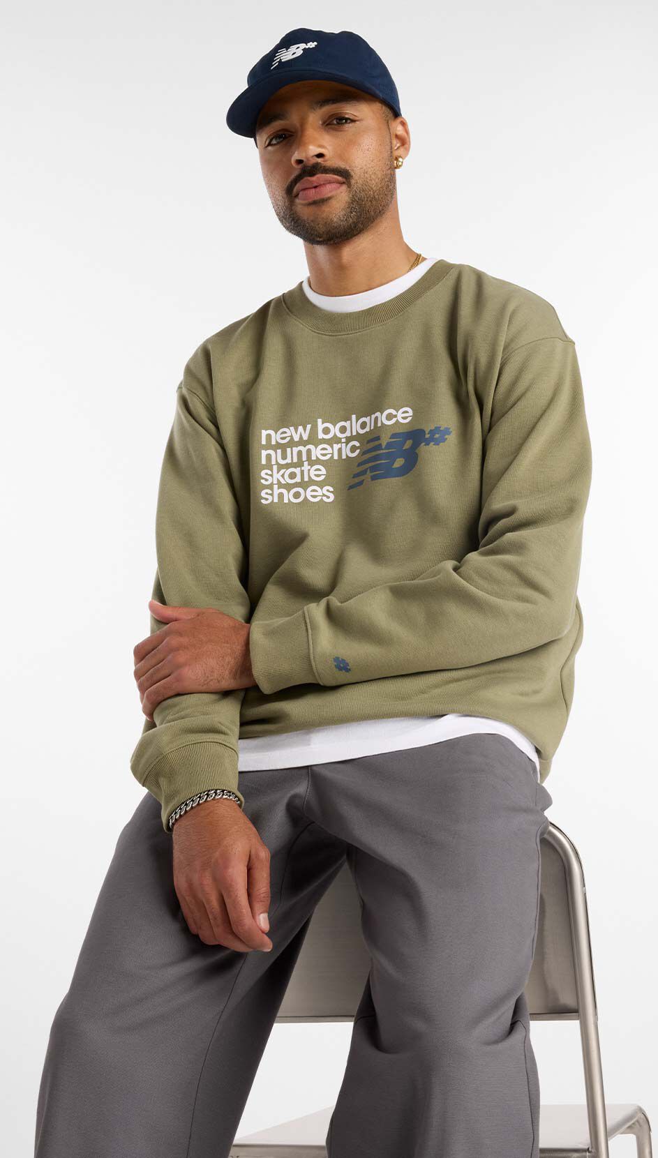  Skateboarder Justin Henry sitting in a studio wearing Numeric apparel. 