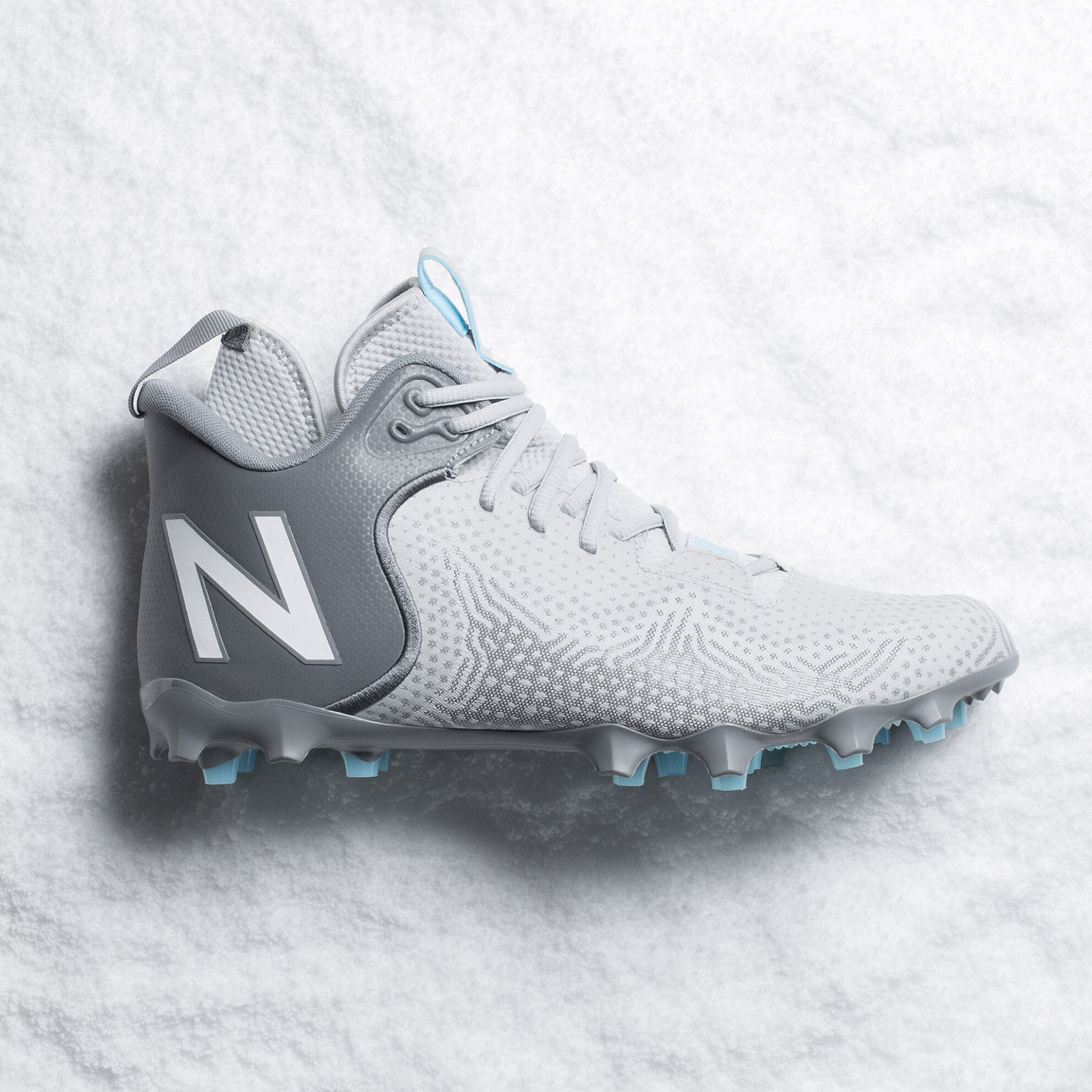 Grey cleat laying on its side on top of snow.