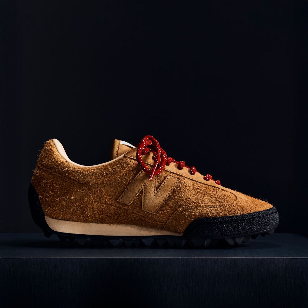 A brown suede Gator Run shoe on a black background.