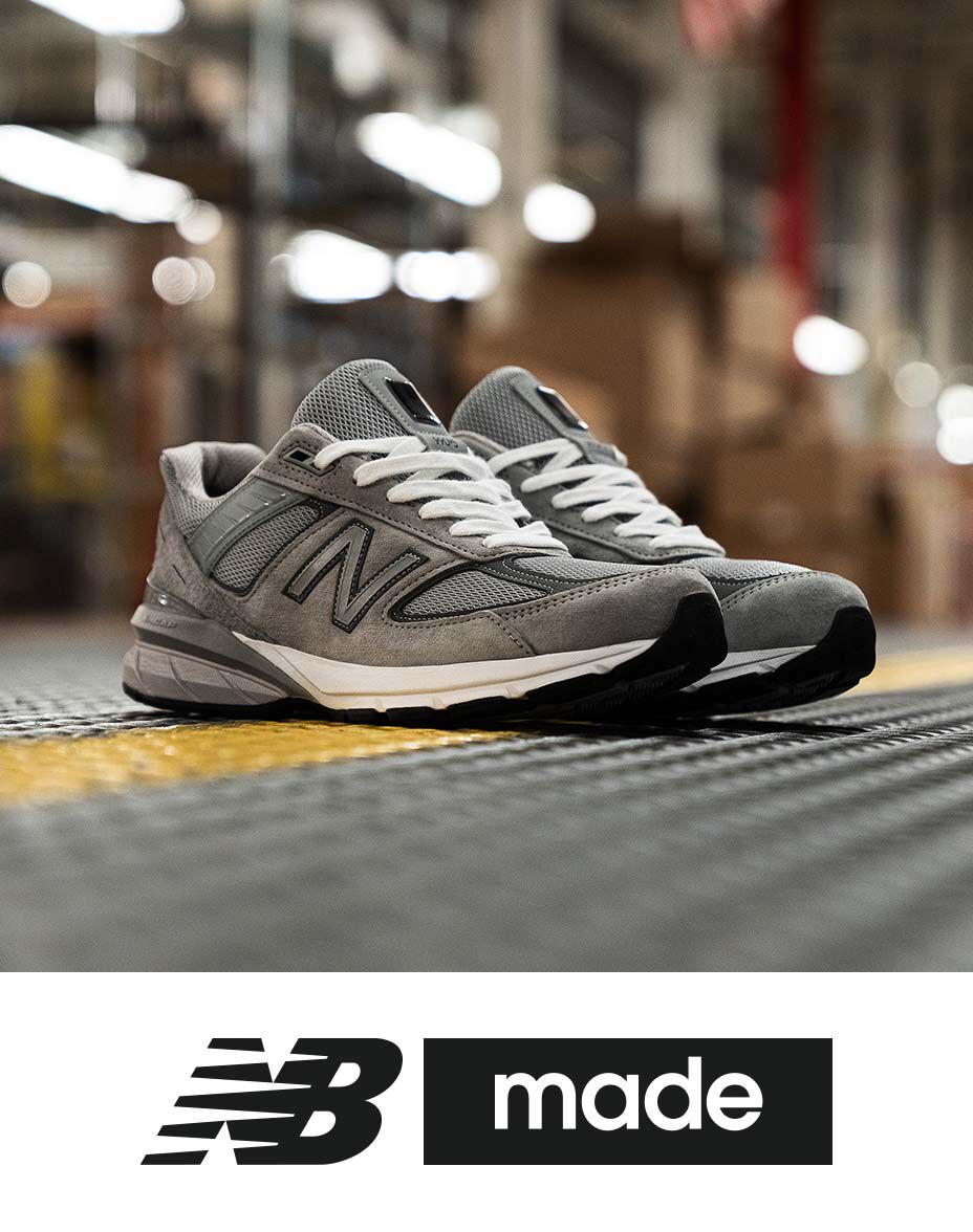 Grey 990 shoes posed on factory floor with NB Made logo below