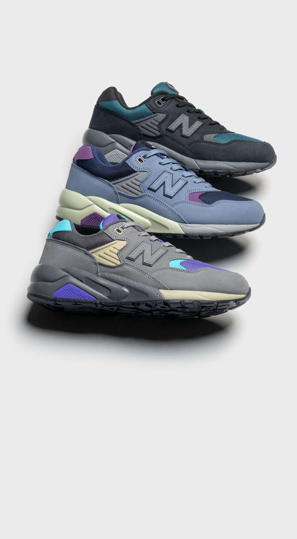 3 New Balance 580 shoes posed in a line against a grey studio background showcasing the color options available 