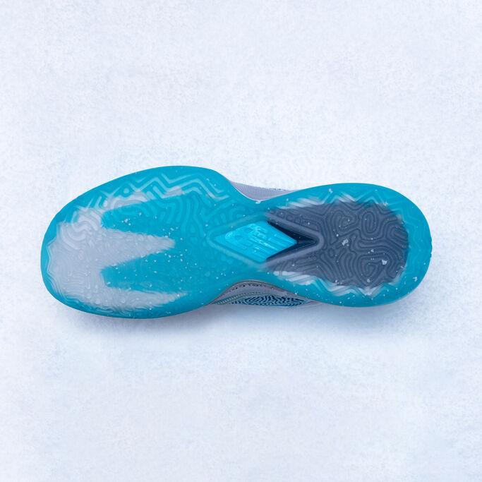 Bottom sole of the shoe is facing upward sitting on snow.