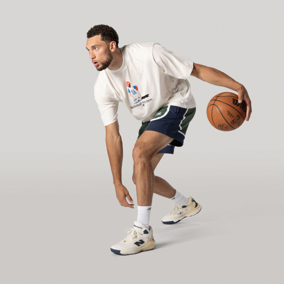 Zach LaVine dribbling a basketball in a white t-shirt and green/blue shorts.    