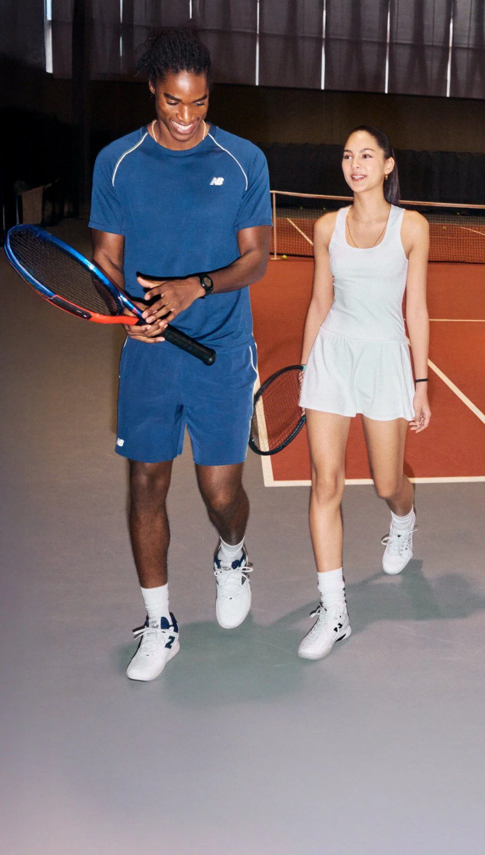 Two tennis players walk together on an indoor court.
