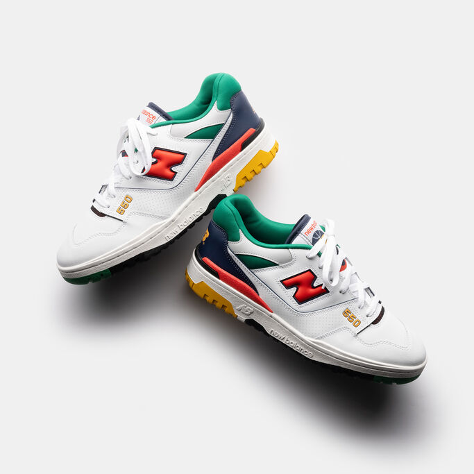 Pair of retro basketball shoes sitting on top of each other with dramatic lighting.