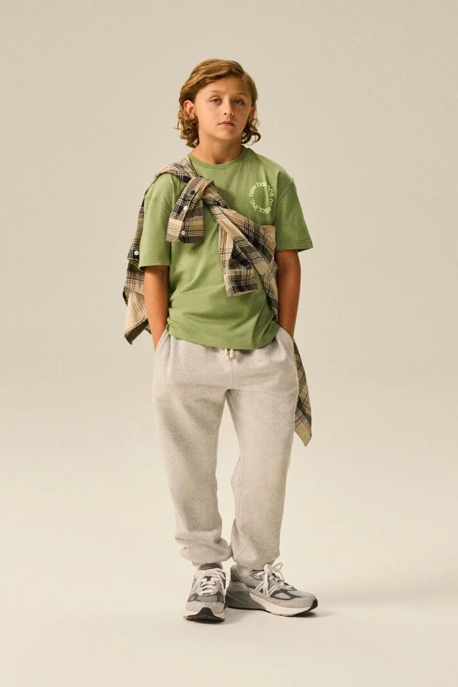 Boy wearing a pair of 990v6 shoes.