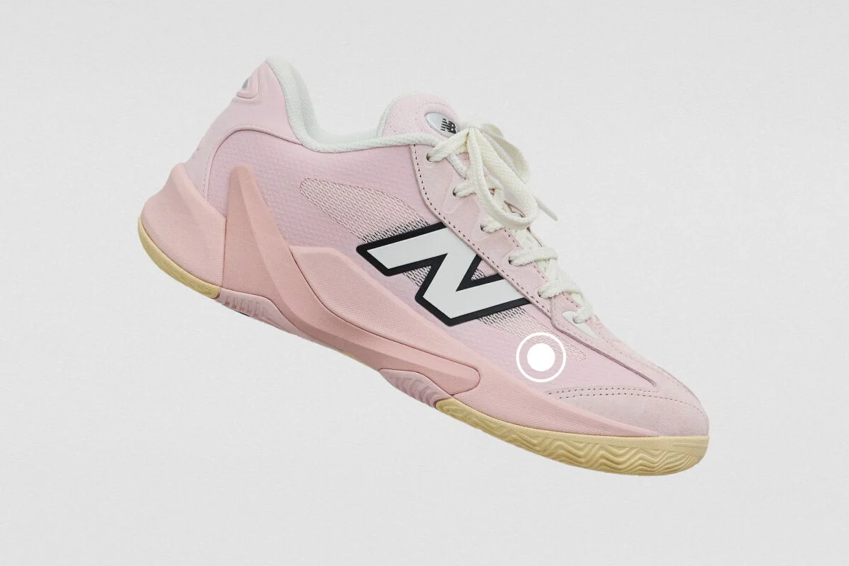 Light pink New Balance athletic sneaker with a mesh upper, oversized side logo, and gum rubber outsole.