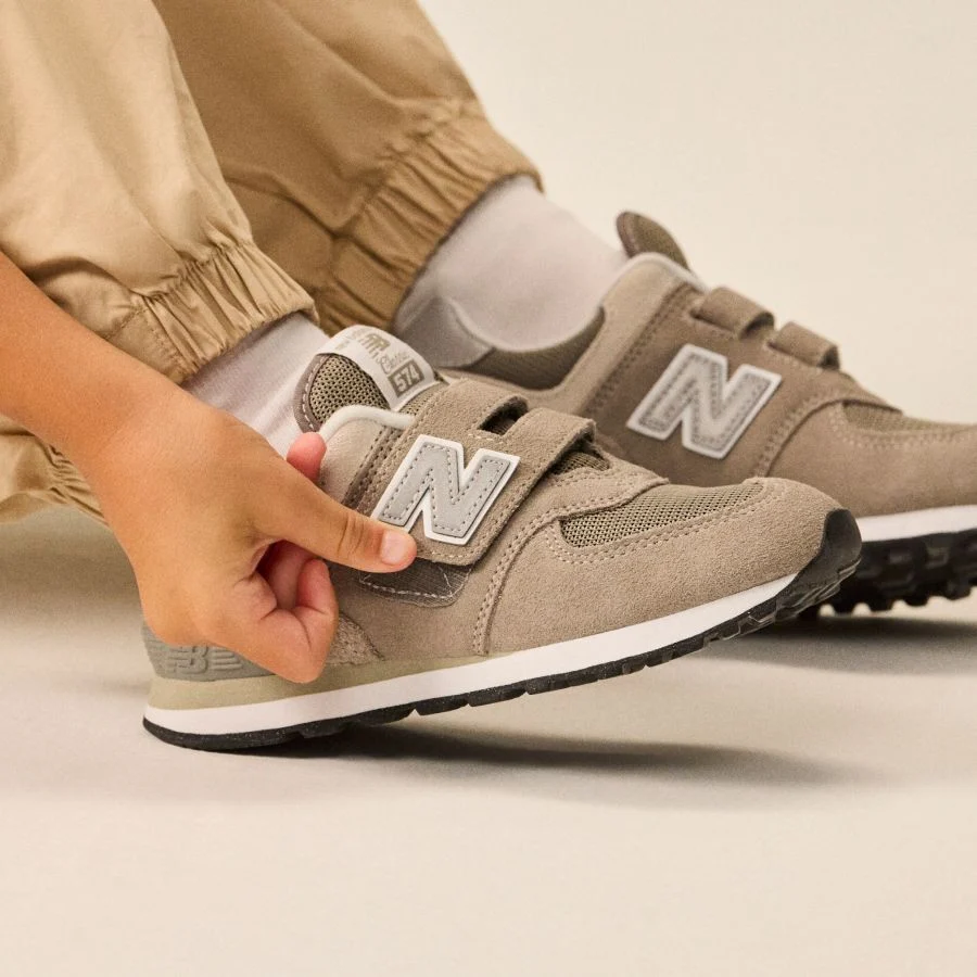 Close up of someone fastening the velcro on 574 shoes.