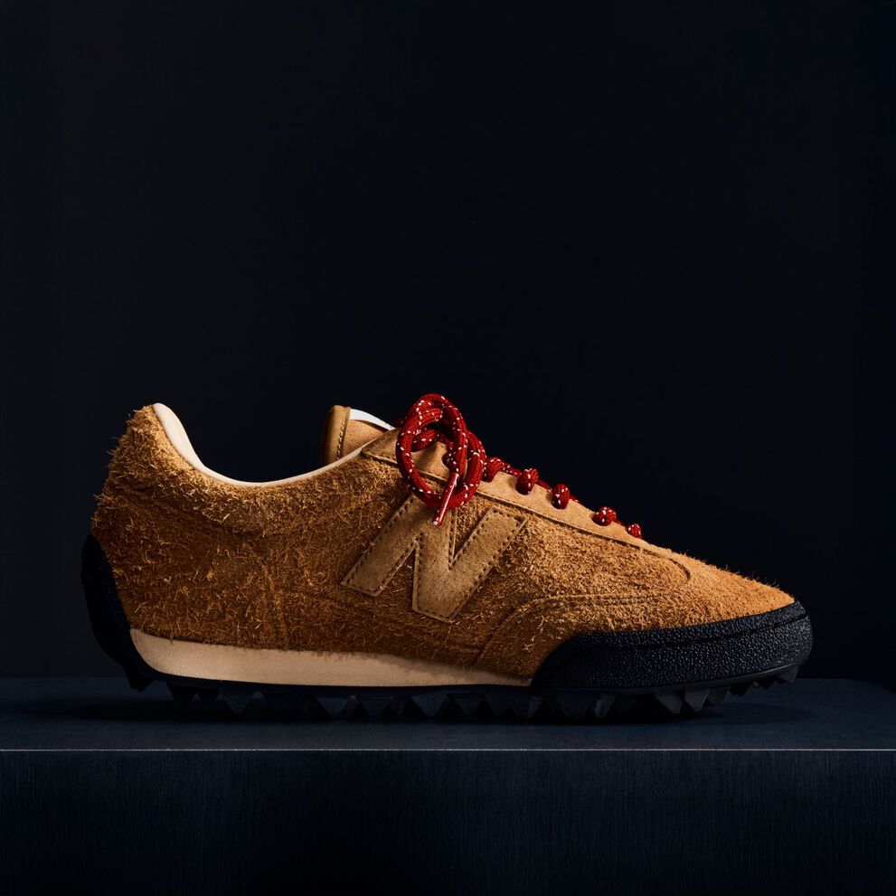 A brown suede Gator Run shoe on a black background.