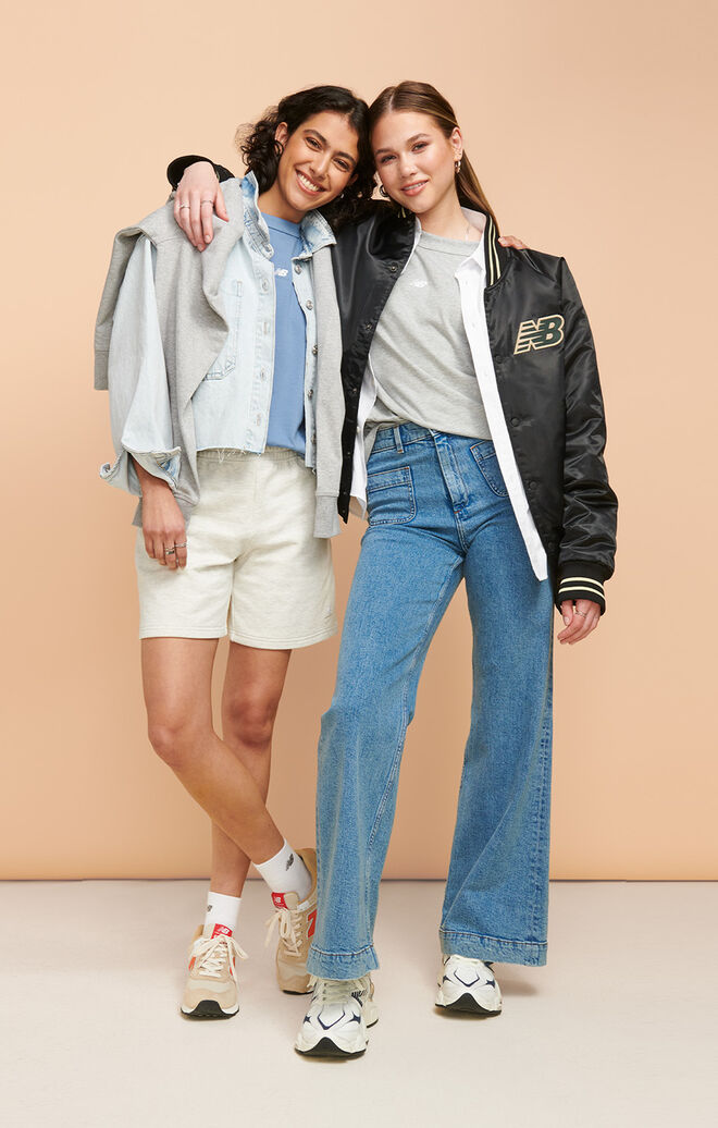 Two young women posing together wearing head-to-toe NB gear