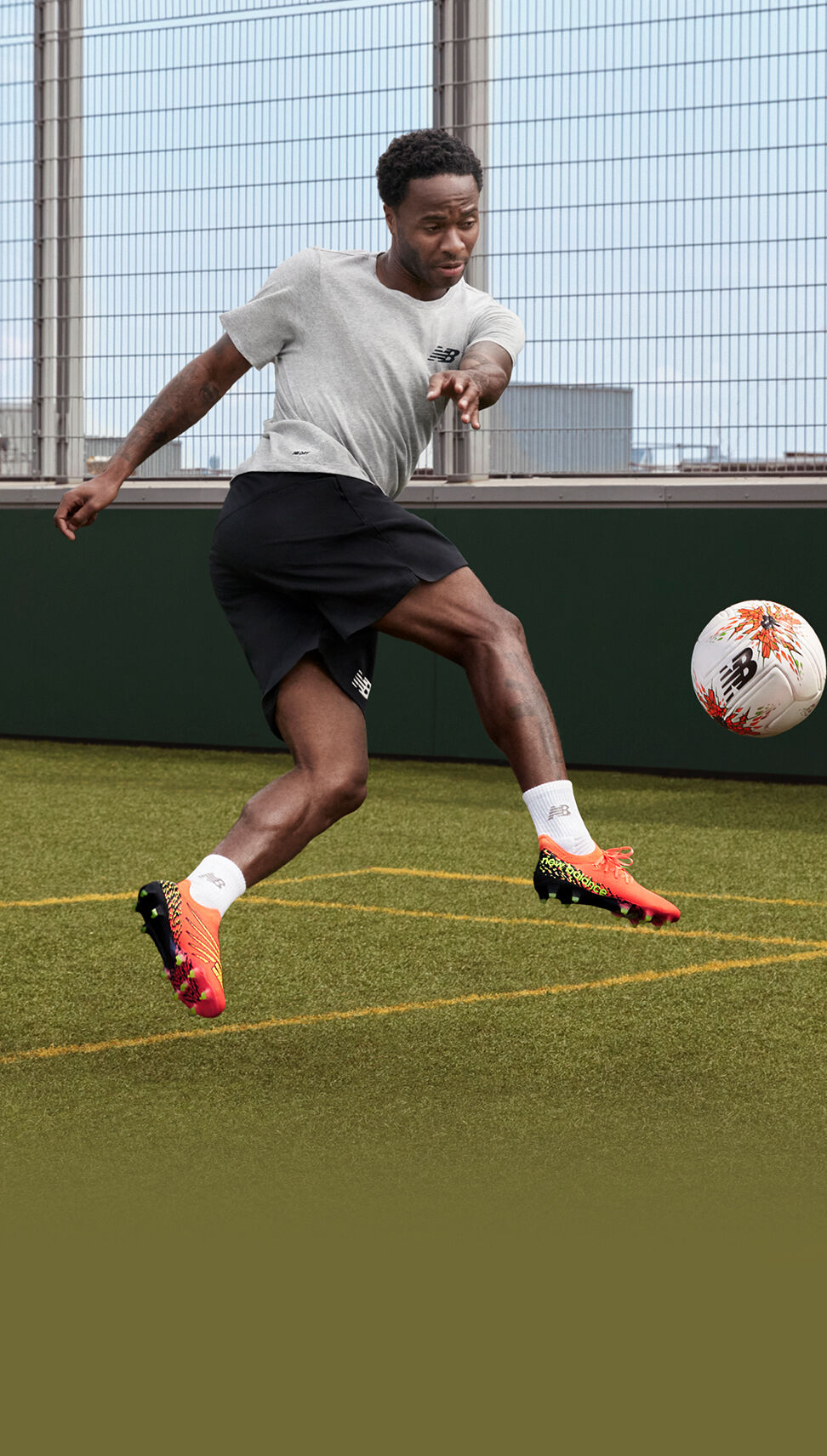 Raheem Sterling kicking a ball on a practice field. 