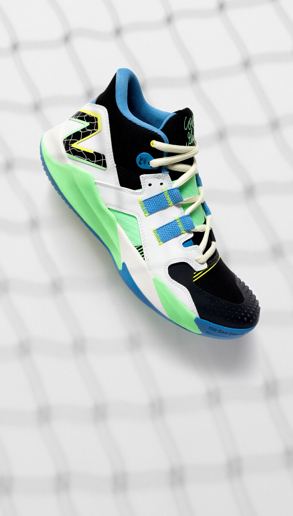 One white, blue, and green CG1 shoe in studio with a tennis net in the background. 