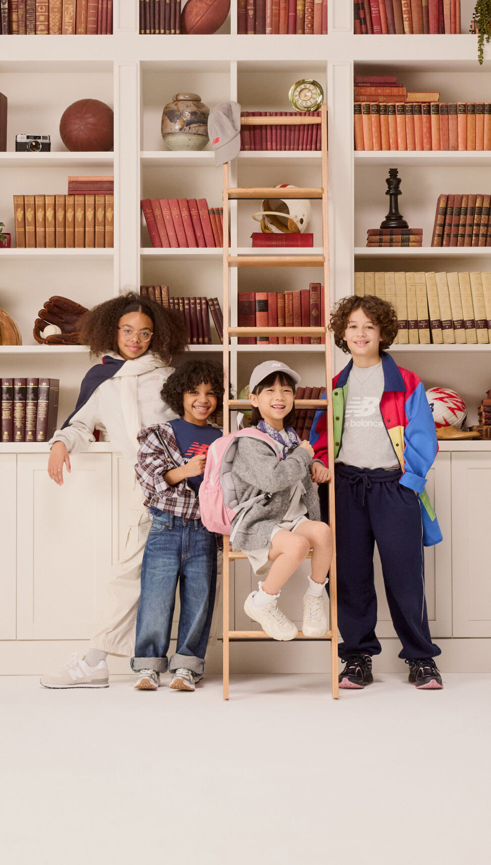 Group of young kids standing in front of a bookshelf. 