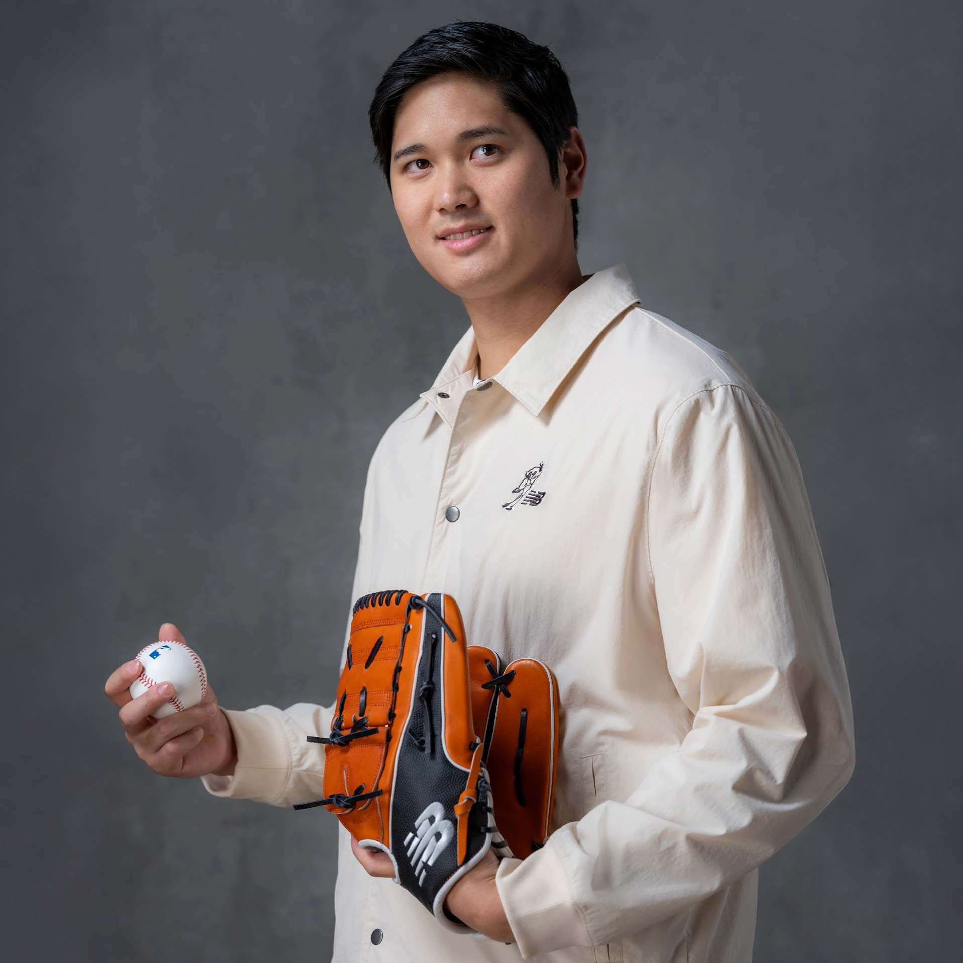   Shohei Ohtani standing with a baseball glove wearing New Balance apparel. 