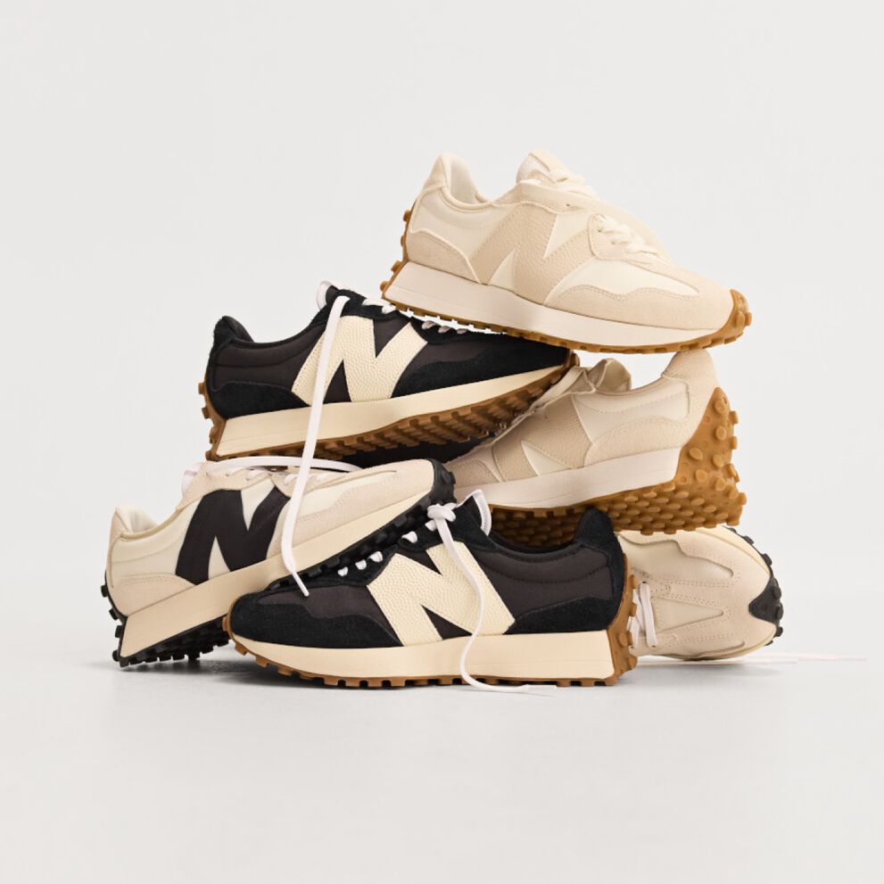 Pile of multiple New Balance sneakers on white background. 