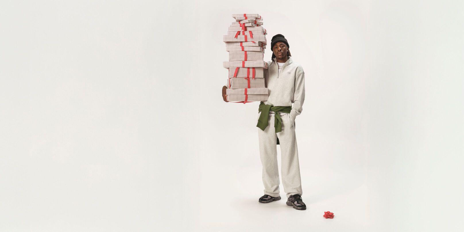 Soccer athlete standing in a white matching set holding gifts.
