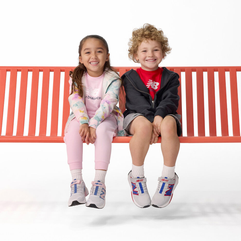 Niño y niña sentados en banco rojo