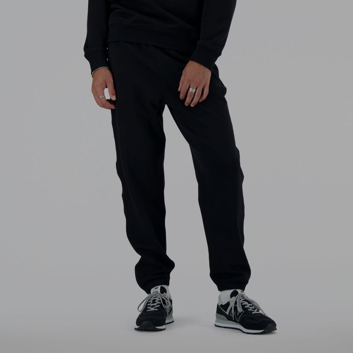 A man wearing black New Balance sweatpants.