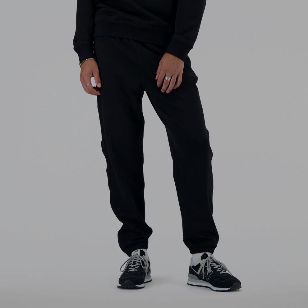 A man wearing black New Balance sweatpants.