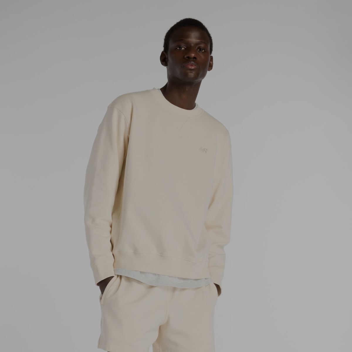 A man in a cream colored matching New Balance outfit.