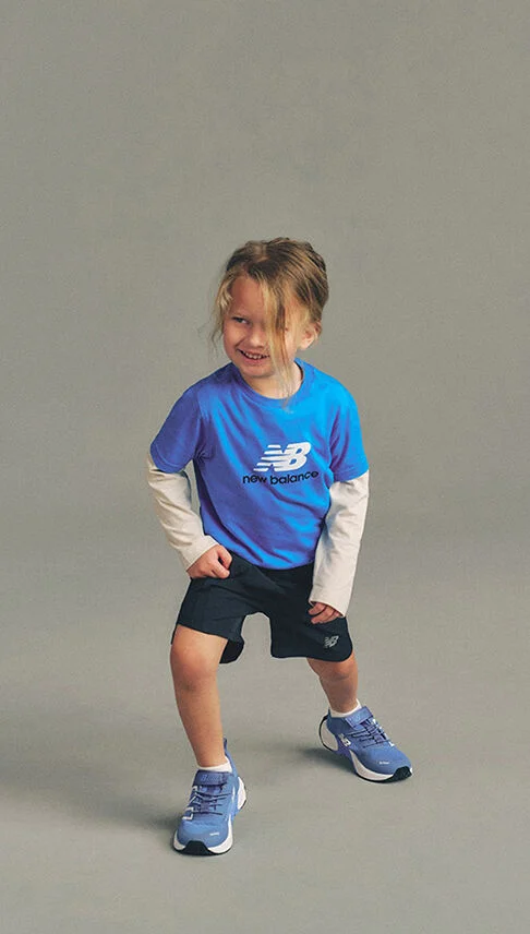 Kid stretching against a grey studio background.