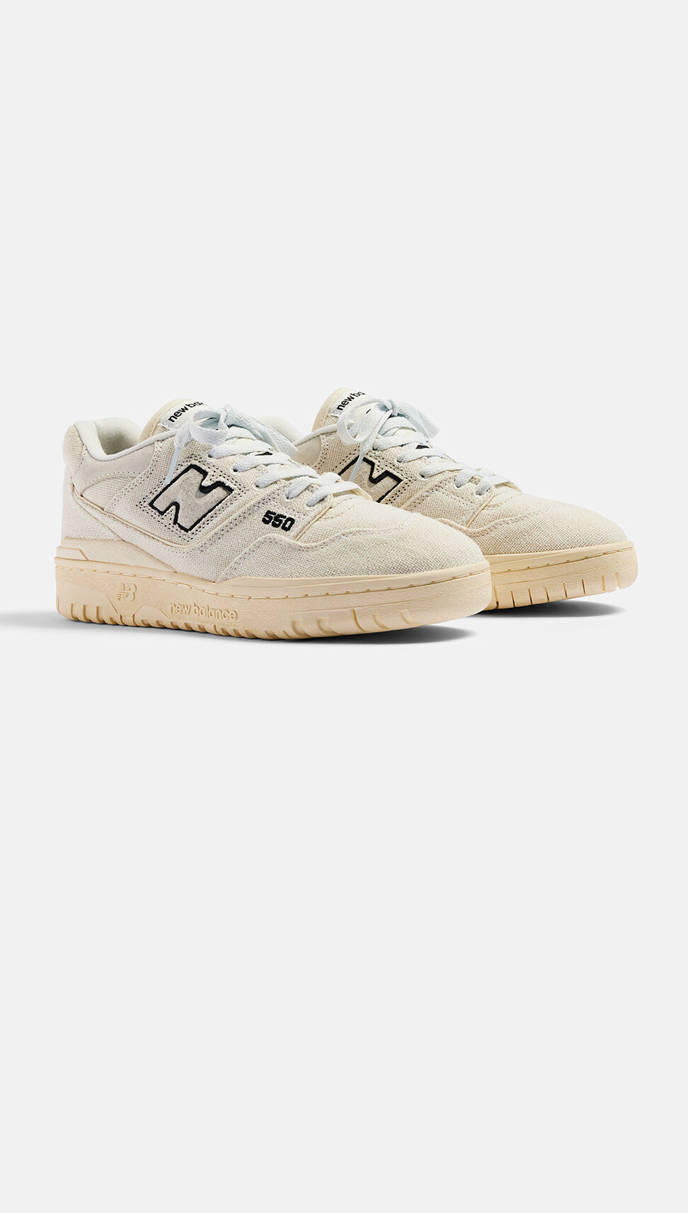Pair of off-white basketball shoes sitting on a grey background.