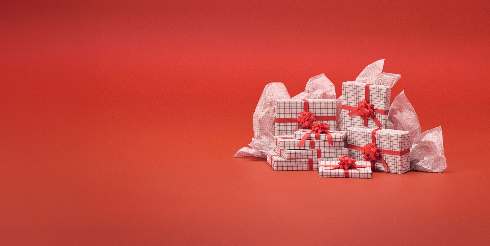 Cajas blancas de regalo delante de un fondo rojo.