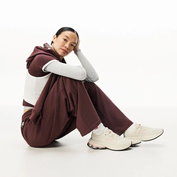 A woman sitting down on the ground with her head resting on her hand 