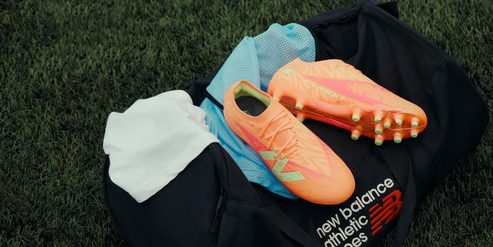 Furon cleats placed on top of a New Balance duffle bag.