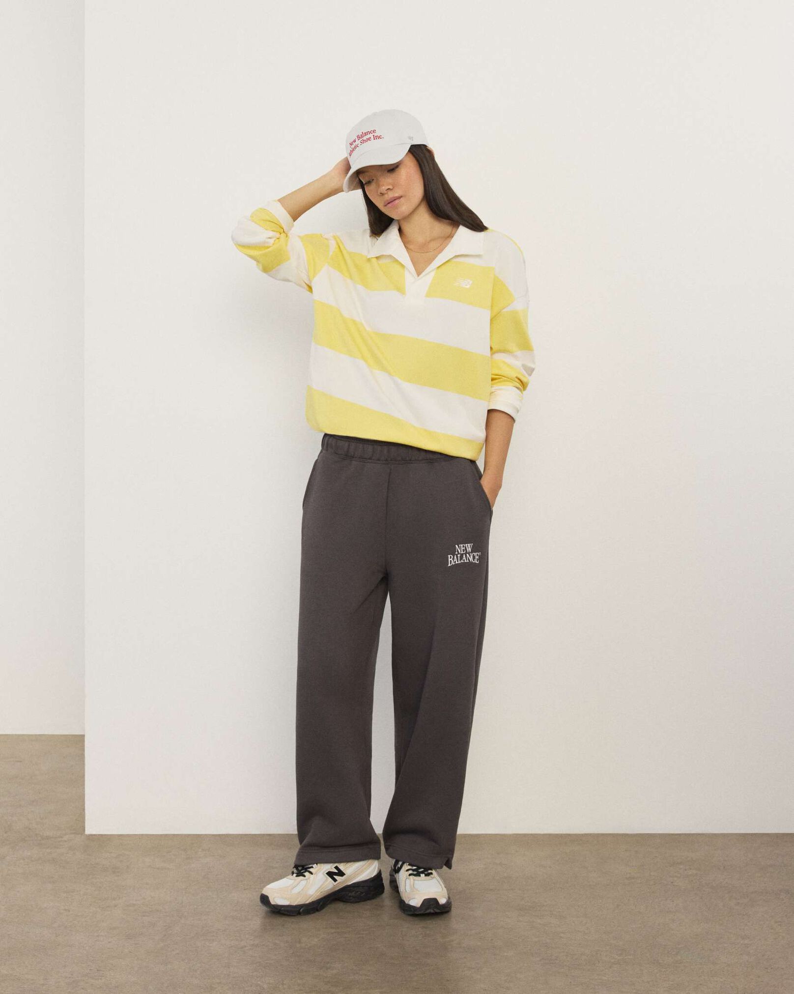 A woman standing in front a white wall.